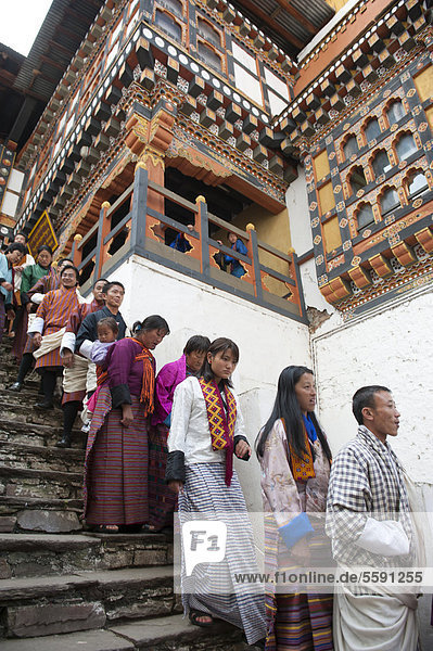Tibetan Buddhist festival  people wearing the traditional Gho robe standing on a staircase in a queue  Rinpung Dzong Monastery and Fortress  courtyard  Paro  Himalayas  Bhutan  South Asia  Asia