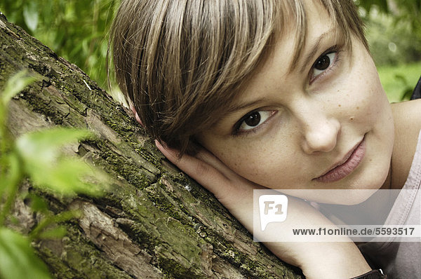 Young woman lying on branch  portrait