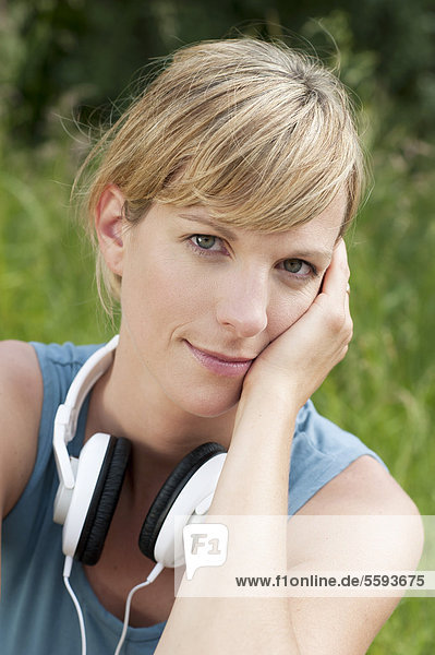 Mittlere erwachsene Frau mit Kopfhörer  lächelnd  Portrait