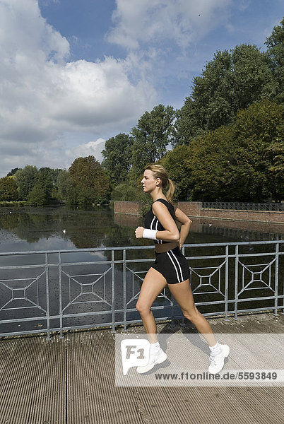 Deutschland  Nordrhein-Westfalen  Düsseldorf  Junge Frau beim Laufen im Park