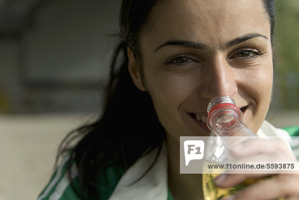 Deutschland  Nordrhein-Westfalen  Düsseldorf  Junge Frau mit Flasche  lächelnd