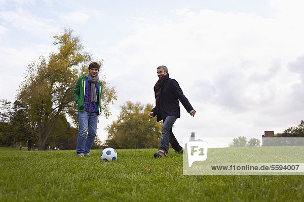 Mann spielt Fußball im Park  lächelnd