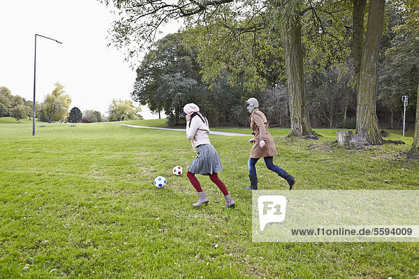 Frau spielt Fußball im Park