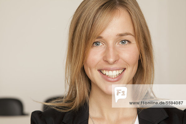 Junge Frau im Büro  lächelnd  Portrait