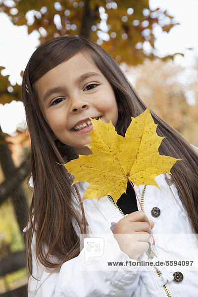 Girl holding leaf  smiling  portrait
