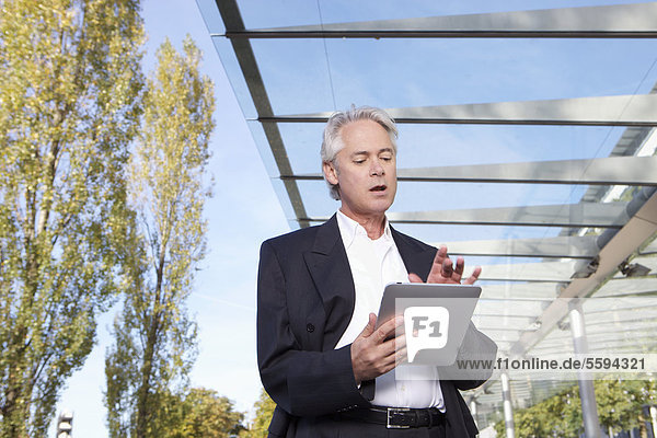 Deutschland  Bayern  München  Geschäftsmann mit digitalem Tablett