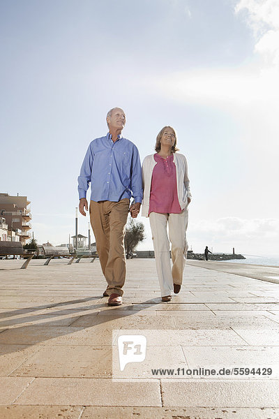 Spain  Mallorca  Senior couple walking together  smiling