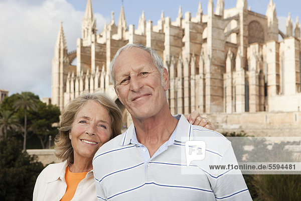 Spanien  Mallorca  Palma  Seniorenpaar lächelnd mit Kathedrale Santa Maria  Portrait