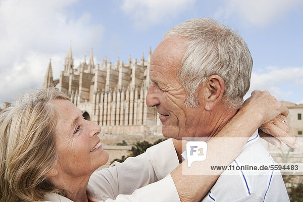 Spanien  Mallorca  Palma  Seniorenpaar lächelnd mit Kathedrale Santa Maria  Portrait