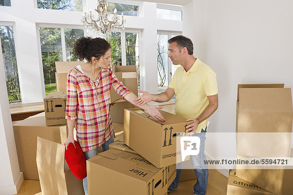 Germany  Bavaria  Grobenzell  Couple packing cardboard boxes for moving house
