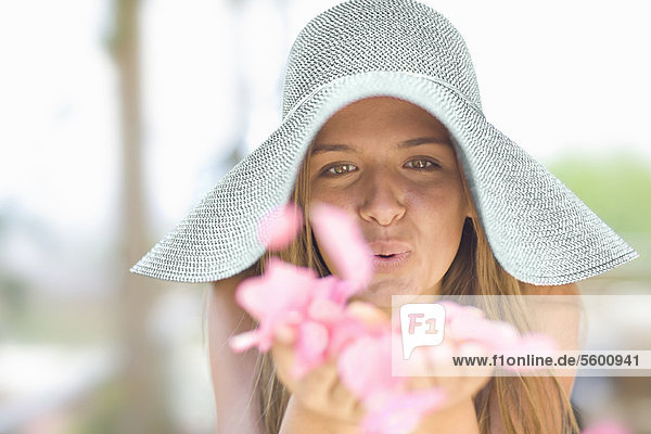 Girl in sunhat playing with flowers