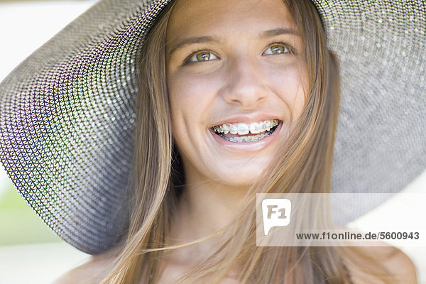Teenage girl in braces wearing sunhat