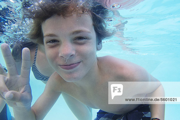 Lächelnder Junge spielt im Pool