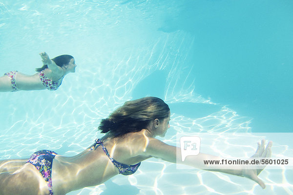 Frauen in Bikinis schwimmen im Pool
