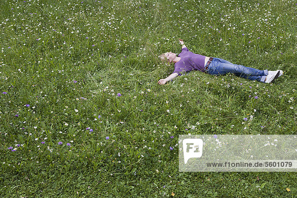 Lächelnde Frau im Gras liegend