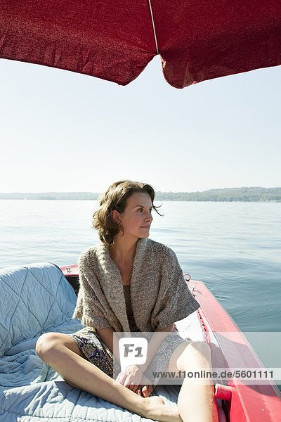 Woman relaxing in boat on still lake