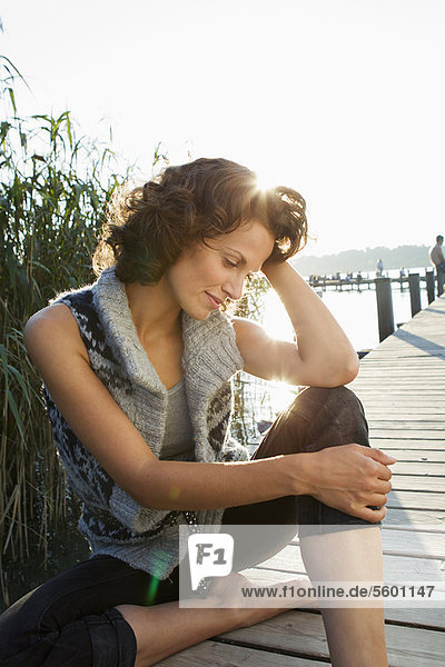 Smiling woman sitting on pier