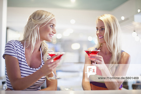 Smiling women having cocktails together