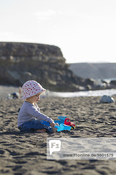 Toddler playing with shovel on beach