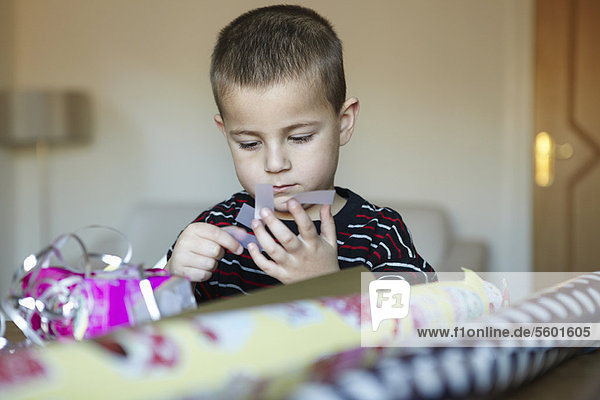Boy wrapping presents at desk