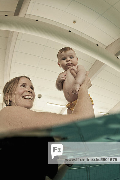 Woman playing with baby in pool