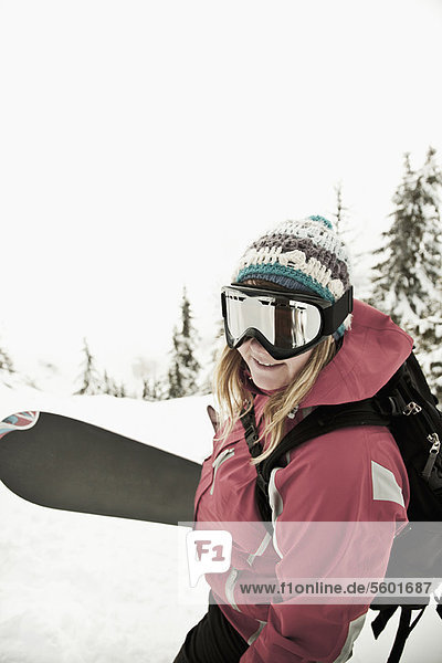 Snowboarder carrying board in snow
