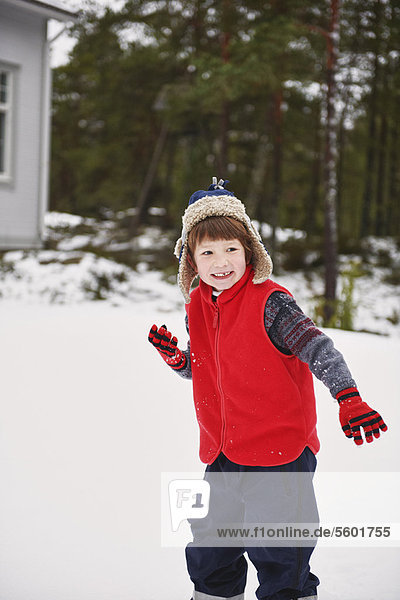 Boy playing in snow outdoors
