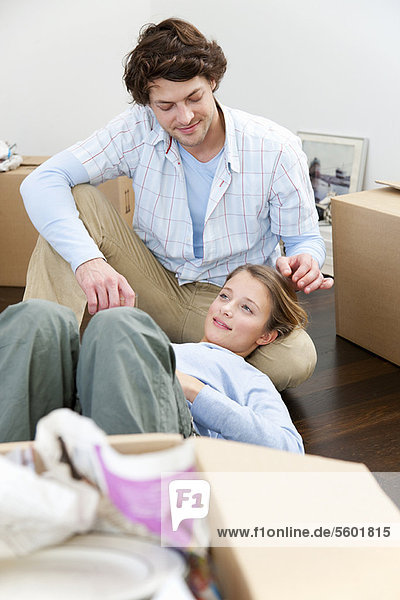 Couple sitting on floor with boxes
