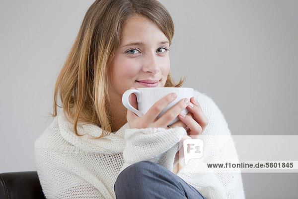 Smiling woman drinking cup of coffee