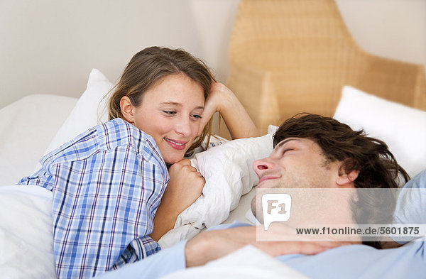 Lächelndes Paar entspannt im Bett