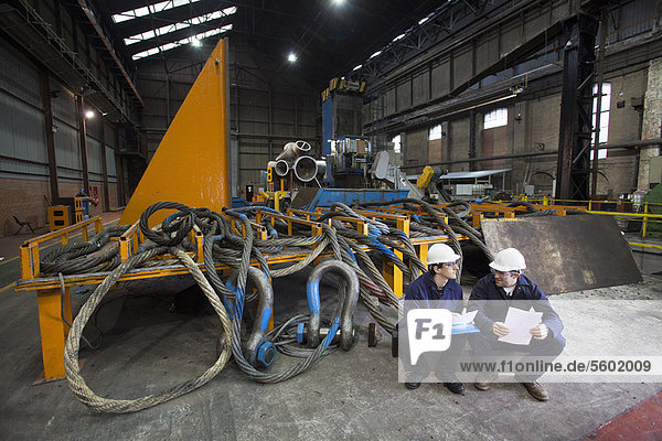 Workers talking in steel forge