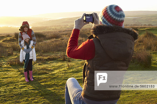 Woman taking picture of family outdoors