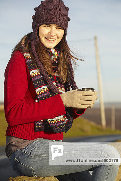 Woman drinking coffee from thermos