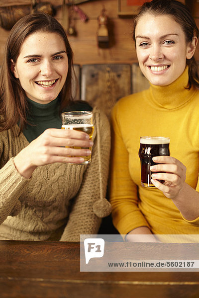 Women drinking beer in pub