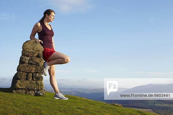 Runner leaning against rock wall