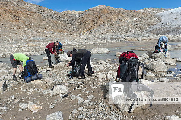Group of hikers preparing for the river-crossing at Mittivakkat Glacier  Peninsula Ammassalik  East Greenland  Greenland