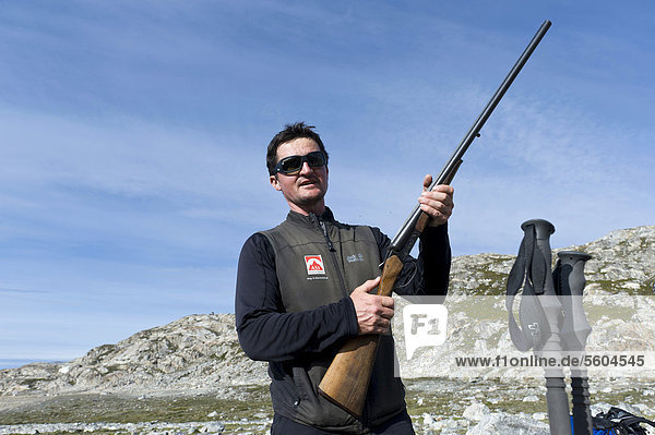 Hiking guide holding a rifle  polar bear protection  Ammassalik Peninsula  Sermilik Fjord  East Greenland  Greenland