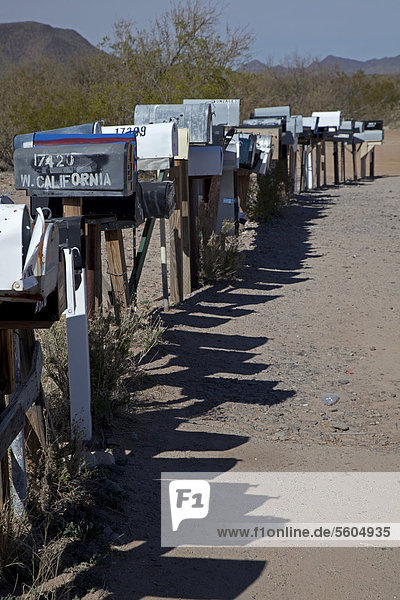 Eine lange Reihe mit Briefkästen stehen entland einer unbefestigten Straße in der Wüste westlich von Tuscon Three Points Arizona USA
