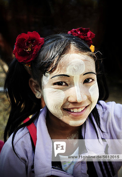 Lächelndes Mädchen mit Thanaka-Paste als Sonnenschutz im Gesicht  in Bagan  Myanmar  Birma  Südostasien  Asien