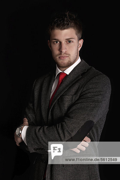 Young man wearing a suit  with arms crossed