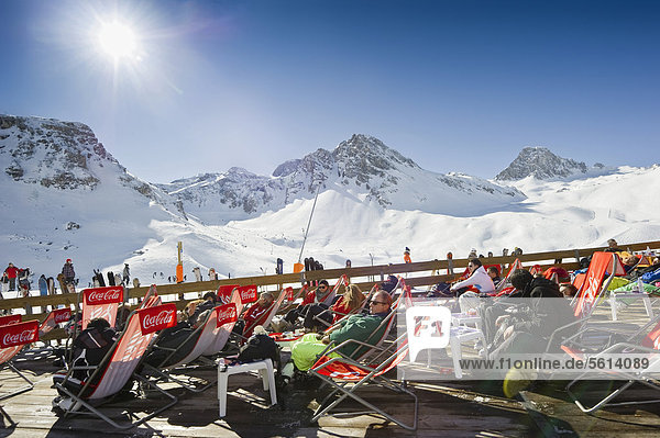 Skiers resting in the sunshine overlooking the snow-covered mountains  Tignes  Val d'Isere  Savoie  Alps  France  Europe