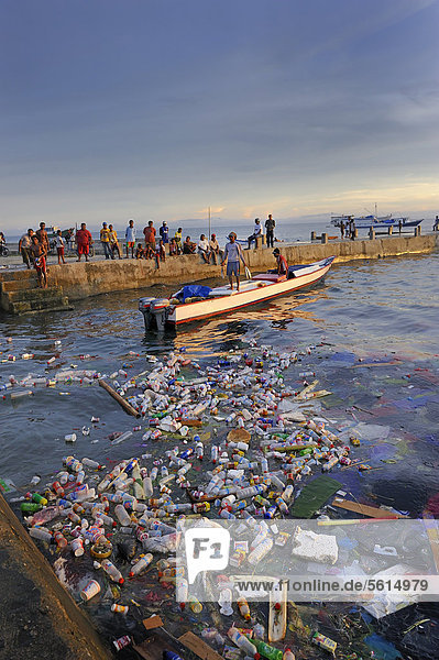 Fishermen landing their catch and taking it to the quay walls  floating plastic debris at front  Kota Biak  Biak Island  Irian Jaya  Indonesia  Southeast Asia  Asia