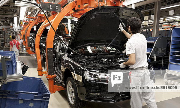 An Audi employee installing hooks on an Audi A4 Sedan  assembly line  Audi plant  Ingolstadt  Bavaria  Germany  Europe