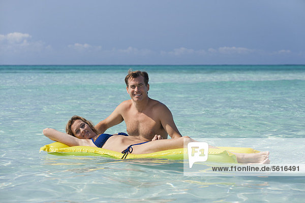 Paar entspannend im Meer  Frau auf dem Pool Floß liegend  Portrait