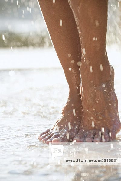 Füße unter der Dusche im Freien