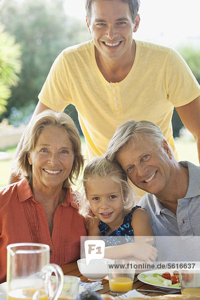 Multi-generation family at breakfast table outdoors  portrait