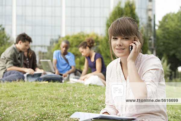 Young woman talking on cell phone  people in background  portrait