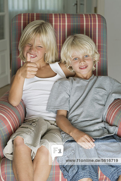 Brothers sitting in armchair  portrait