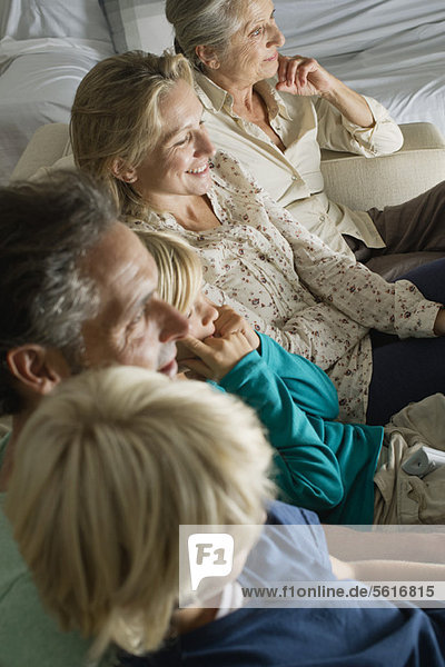 Multi-generation family sitting side by side on sofa  high angle view