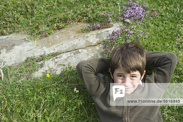 Junge entspannt auf Rasen  Portrait  direkt darüber